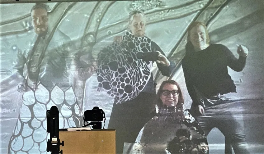 The artists and the researchers playing in front of the screen